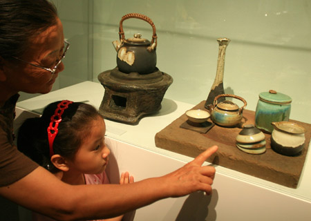 A citizen admires pottery with a child in the National Art Museum of China in Beijing, China, June 20, 2009. (Xinhua/Ding Huanxin) 