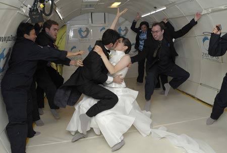 Bride Erin Finnegan and bridegroom Noah Fulmor, both of New York, seal their marriage vows with a kiss during the first weightless wedding aboard a specially-equipped Boeing 727, owned by Zero Gravity Corporation, while flying over the Gulf of Mexico after taking off from Titusville, Florida, June 20, 2009. Finnegan and Fulmor floated into matrimony on Saturday thousands of feet (metres) above the Gulf of Mexico in what organizers said was the world's first weightless wedding held in zero gravity conditions. To recreate the weightless experience without going into space, the plane executed parabolic flight maneuvers, climbing sharply and descending several times during the one-hour flight.