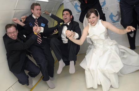 Bridegroom Noah Fulmor and his bride Erin Finnegan, both of New York, float and celebrate with the rest of the wedding party after saying their vows aboard a specially-equipped Boeing 727 of the Zero Gravity Corporation over the Gulf of Mexico, after taking off from Titusville, Florida, June 20, 2009.