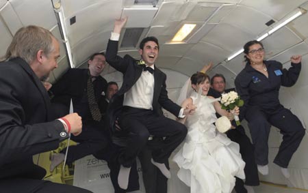 Bride Erin Finnegan (3rd R) and bridegroom Noah Fulmor (3rd L), both of New York, are helped by the rest of the wedding party as they float after performing the first weightless wedding aboard a specially-equipped Boeing 727, owned by Zero Gravity Corporation, while flying over the Gulf of Mexico after taking off from Titusville, Florida, June 20, 2009.