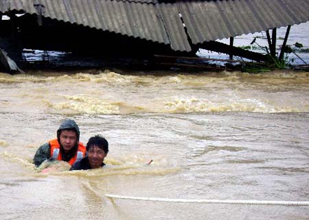 Soldiers of the local frontier defence troop rescue trapped resident in Zhao'an County, southeast China's Fujian Province, June 22, 2009. Affected by tropical storm Linfa, the third this year, heavy rainstorm hit Zhao'an county on Sunday night. Over 100 residents trapped by floods have all been transferred to safe areas by Monday afternoon. (Xinhua/Xu Guoqing) 