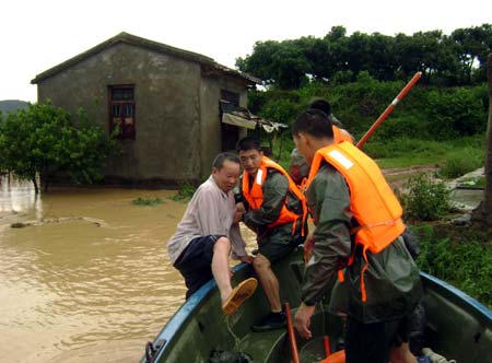 Soldiers of the local frontier defence troop rescue trapped resident in Zhao'an County, southeast China's Fujian Province, June 22, 2009. Affected by tropical storm Linfa, the third this year, heavy rainstorm hit Zhao'an county on Sunday night. Over 100 residents trapped by floods have all been transferred to safe areas by Monday afternoon. (Xinhua/Xu Guoqing)