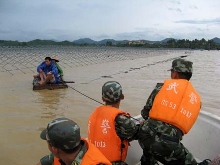 Soldiers of the local frontier defence troop rescue trapped residents in Zhao'an County, southeast China's Fujian Province, June 22, 2009. Affected by tropical storm Linfa, the third this year, heavy rainstorm hit Zhao'an county on Sunday night. Over 100 residents trapped by floods have all been transferred to safe areas by Monday afternoon. (Xinhua/Xu Guoqing) 