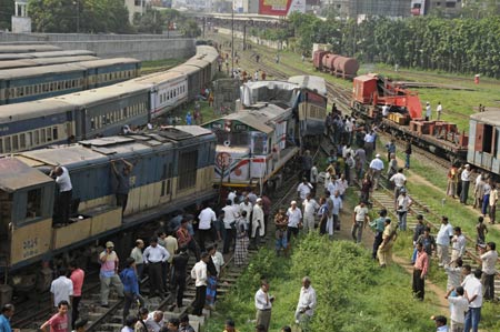 People gather around the damaged trains at the Kamlapur railway Station in Dhaka, capital of Bangladesh, June 22, 2009. Two trains collided head-on in Dhaka on Monday afternoon, leaving at least 2 dead, officials said. (Xinhua/Qamruzzaman)