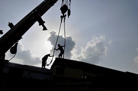 Rescuers work at the site where two trains collided earlier at the Kamlapur railway Station in Dhaka, capital of Bangladesh, June 22, 2009. Two trains collided head-on in Dhaka on Monday afternoon, leaving at least 2 dead, officials said. (Xinhua/Qamruzzaman)