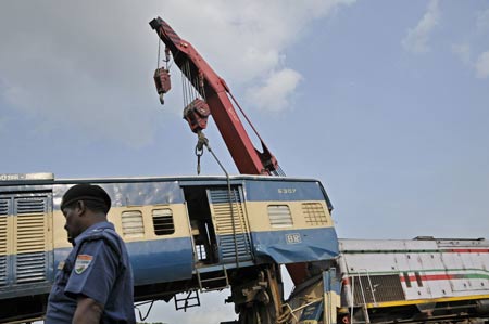 A relief crane moves away a damaged train from the rail track at the site where two trains collided earlier at the Kamlapur railway Station in Dhaka, capital of Bangladesh, June 22, 2009. Two trains collided head-on in Dhaka on Monday afternoon, leaving at least 2 dead, officials said. (Xinhua/Qamruzzaman)