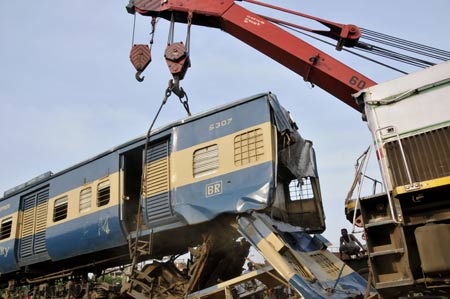 A relief crane moves away a damaged train from the rail track at the site where two trains collided earlier at the Kamlapur railway Station in Dhaka, capital of Bangladesh, June 22, 2009. Two trains collided head-on in Dhaka on Monday afternoon, leaving at least 2 dead, officials said. (Xinhua/Qamruzzaman)