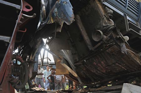 People gather around the damaged trains at the Kamlapur railway Station in Dhaka, capital of Bangladesh, June 22, 2009. Two trains collided head-on in Dhaka on Monday afternoon, leaving at least 2 dead, officials said. (Xinhua/Qamruzzaman)