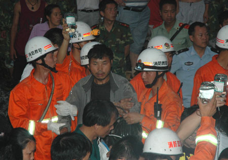 A trapped worker is helped out of a flooded gold mine in Tianzhu County of Qiandongnan Autonomous Prefecture of Miao and Dong Nationalities, southwest China's Guizhou Province, June 23, 2009. All seven trapped workers in a flooded gold mine in the county were saved on June 23 after a 20-hour rescue effort. 