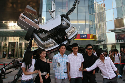 Chinese pop duo Yu Quan (right1, 2) pose for a photo in front of a transformer model, which was unveiled on Tuesday, June 23 to mark the debut of the sci-fi film 'Transformers: Revenge of the Fallen'.