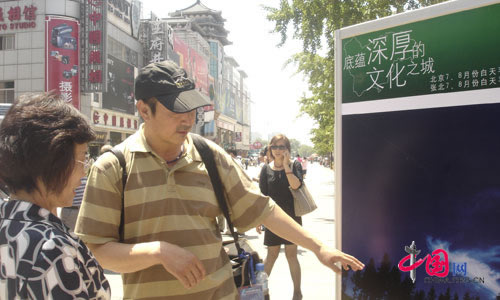 The photographer Xu Baokuan talks with a visitor.