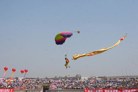 A parachuter performs style jumping at the opening ceremony of an invitational skydiving competition in Kaifeng, central China's Henan Province, June 25, 2009. More than 40 parachuting athletes take part in the competition. [Li Junsheng/Xinhua]