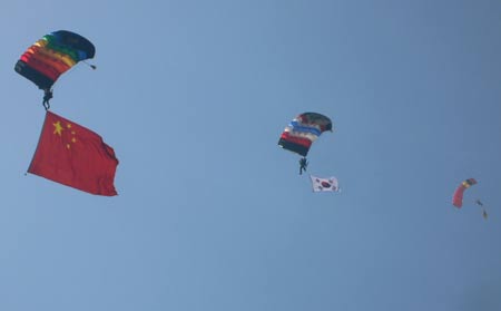 Parachuters perform style jumping at the opening ceremony of an invitational skydiving competition in Kaifeng, central China's Henan Province, June 25, 2009. [Li Junsheng/Xinhua]