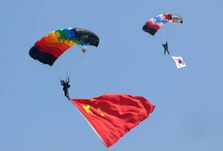 Parachuters perform style jumping at the opening ceremony of an invitational skydiving competition in Kaifeng, central China's Henan Province, June 25, 2009. [Li Junsheng/Xinhua]