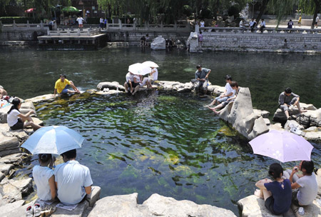 Citizens rest beside a spring in Jinan, capital of east China's Shandong Province, June 25, 2009. The city's highest temperature hit over 40 degrees Celsius on Thursday. [Xinhua]