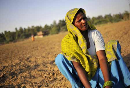 An Indian woman works in the droughty farmland on the outskirts of southern New Delhi, captial of India, June 25, 2009. Searing heat wave continued to scorch the plains of north India with temperatures of its capital remained above 42 degrees Celsius for days. According to meteorological offcials, the extreme heat conditions would probably persist for a period of time due to delayed monsoon. [Xinhua]