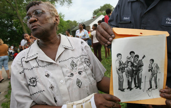 Mabele Moore, a neighbor of pop star Michael Jackson, holds an autographed photo outside his childhood home of Pop Star Michael Jackson on June 25, 2009 in Gary, Indiana.