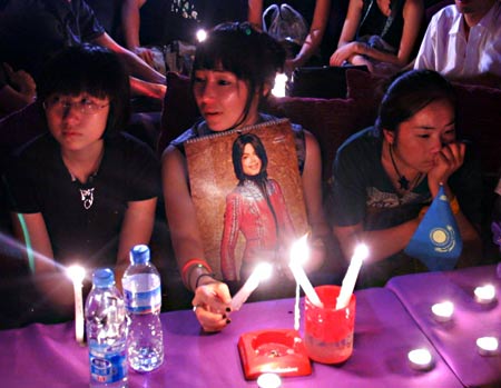 Chinese fans light candles as they attend a night gathering to mourn for the late U.S. megastar Michael Jackson, in Beijing, China, June 26, 2009. The 50-year-old "King of Pop" was pronounced dead on Thursday afternoon at the Medical Center of the University of California in Los Angeles, after he was in a full cardiac arrest.