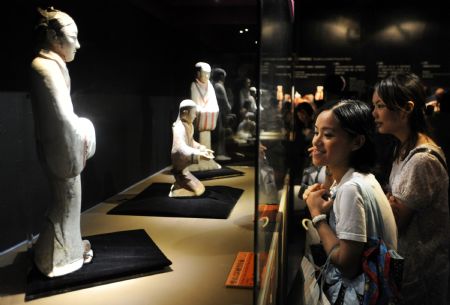 Visitors gaze at a range of colorful clay figurines excavated from the Mausoleum of Emperor Jingdi of theWestern Han Dynasty (202 BC - 8 AD), during the Smiling Color Clay Figurines special exhibition of cultural relics from the underground kingdom of Emperor Jingdi who reigned from 156 BC to 141 BC, which opens in Taipei, southeast China's Taiwan, June 26, 2009.