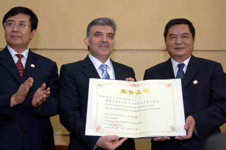 Visiting Turkish President Abdullah Gul (C) is conferred the Honorary Doctorate of Economics of Northwest University in Xi'an, capital of northwest China's Shaanxi Province, June 27, 2009. (Xinhua/Ding Haitao