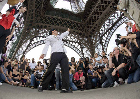 A Michael Jackson impersonator dances for fans under the Eiffel Tower in Paris, June 28, 2009.