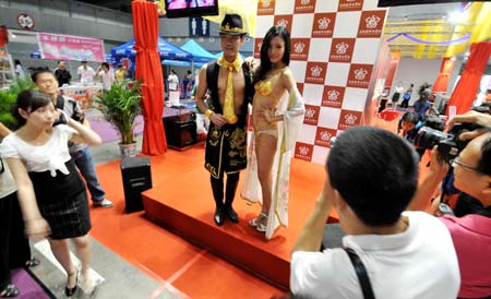 Two Chinese models show off a set of pure gold underwear for woman and pure gold tie and wrist strap for man at an exhibition in southwest China's mountain city of Chongqing, June 26, 2009. The gold dressing is said to worth 4 million Yuan, or about 585,396 U.S. dollars. (Xinhua/Zhong Guilin)