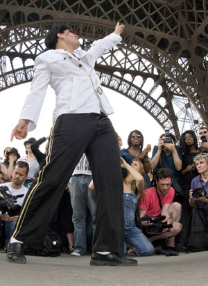 A Michael Jackson impersonator dances for fans under the Eiffel Tower in Paris, June 28, 2009.