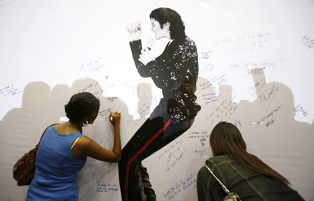 Michael Jackson fans write messages during a tribute to the late pop icon at a shopping mall in Kuala Lumpur June 28, 2009.