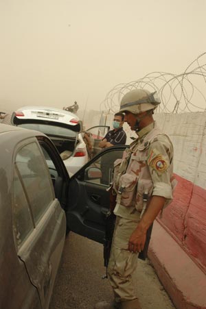 A soldier of Iraqi security forces searches a car at a checkpoint in Baghdad, capital of Iraq, on June 28, 2009. As part of a security pact signed between Baghdad and Washington last year, U.S. troops will withdraw from Iraq's cities, towns and villages by June 30, 2009 to their bases, and will leave the country by December 31, 2011. (Xinhua/Gao Shan)
