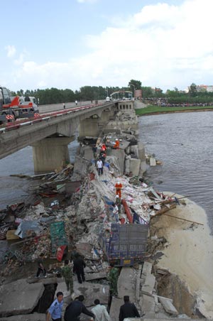 Rescuers work at Xida Bridge in Tieli, a city of notheast China's Heilongjiang Province, June 29, 2009. Part of Xida Bridge, a parallel road bridge spanning Hulan River of Tieli, collapsed early Monday, causing at least one dead, and 8 vehicles plunged into the water below. (Xinhua/Wang Song)