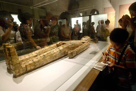 Local citizens watch the National Treasures -- Exposition of Cultural Relics under Collection of the National Museum of China, in the Liaoning Provincial Museum at Shenyang, northeast China's Liaoning Province, June 28, 2009. The exposition, which is open to the public gratis and will last until August 31, presents a total of 78 pieces of national treasure-level cultural relics dated back from the paleolithic period to the Tang Dynasty (618-907), of which the top-notch cultural relics accounting for 72 percent of the total exhibits. (Xinhua/Zhang Wenkui)