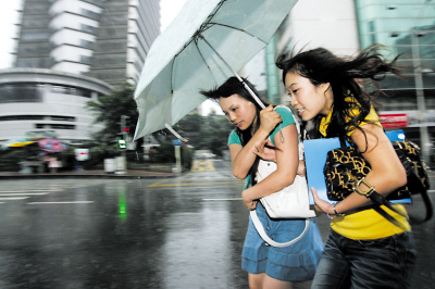 Two girls walk in heavy rain in China's Chongqing Municipality June 27, 2009. [Chongqing Economic Times]