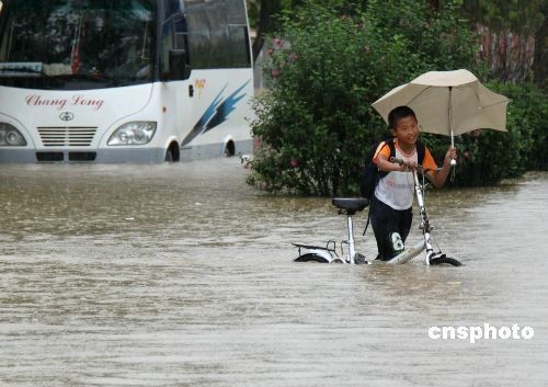 A boy and a bus wade through a flooded street in Lujiang County, east China's Anhui Province June 30, 2009.