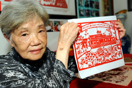 82-year-old Yuan Xiuying shows her paper-cut work in Zherong County, southeast China's Fujian Province, June 30, 2009. Yuan Xiuying is an inheritor of the Intangible Cultural Heritage of Zherong County. The paper-cuts in Zherong County have been sold to many countries and regions including USA, Canada, Australia, Egypt and Singapore. (Xinhua/Peng Zhangqing)