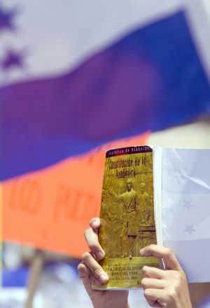 Supporters of Honduras' post-coup leader Roberto Micheletti holding the copy of constitution and the national flag take part in a rally in a public park in Tegucigalpa, capital of Honduras, June 30, 2009. Thousands of supporters of the interim President Roberto Micheletti joined anti-Zelaya rally here on Tuesday protesting against the change of the Institutions and the return of ousted President Zelaya. (Xinhua/David De La Paz)