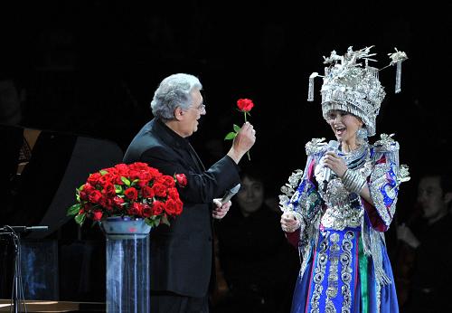 Spanish tenor Placido Domingo (L) presents a flower to Song Zuying, a famous Chinese singer, during the 'Beijing Bird's Nest Summer Concert' at the National Stadium, or the 'Bird's Nest', in Beijing, June 30, 2009. 