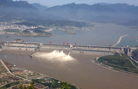 Photo taken on July 1, 2009 shows the Three Gorges Dam opening two deep-holes and a trash way hole for sluicing the mounting flood water, in Yichang, central China's Hubei Province. The Three Gorges Reservoir has high influx of flooded water along with the arrival of Yangtze River's main flood season with recent days' persistent rainfalls. [Wen Zhenxiao/Xinhua] 