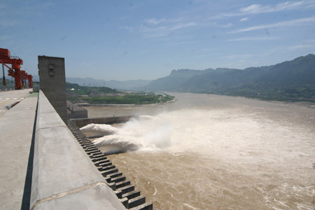 Photo taken on July 1, 2009 shows two deep-holes and a trash way hole opened for sluicing the mounting flood water on the Three Gorges Dam in Yichang, central China's Hubei Province. [Li Kaiyong/Xinhua]