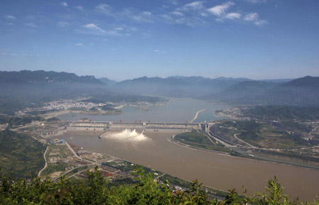 Photo taken on July 1, 2009 shows the Three Gorges Dam opening two deep-holes and a trash way hole for sluicing the mounting flood water in Yichang, central China's Hubei Province. [Wen Zhenxiao/Xinhua]
