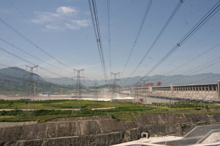 Photo taken on July 1, 2009 shows the power transmission lines at the Power Plant on the left bank of the three Gorges Dam, which opens two deep-holes and a trash way hole for sluicing the mounting flood water in Yichang, central China's Hubei Province. [Li Kaiyong/Xinhua]