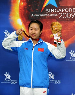 China's Zhong Chunchan poses on the podium during the awarding ceremony of the girls' 10m air rifle event at the First Asian Youth Games held in Singapore, July 1, 2009. Zhong Chunchan claimed the title with a score of 499.5. 