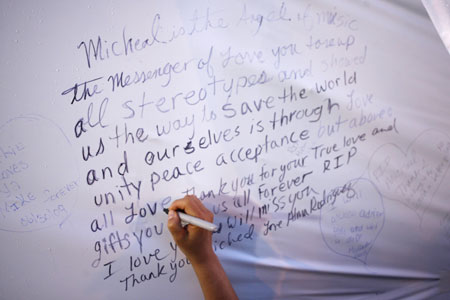 A fan writes a message on a wall following the Michael Jackson public memorial at the Apollo Theater in New York June 30, 2009. The Apollo will welcome fans 600 at a time to enter the theater to pay their respects, hear Jackson's music spun by New York DJs and see a a video tribute to the late pop star.