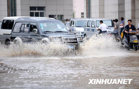 Pedestrians and vehicles wade through a flooded street in Nanchang City, east China's Jiangxi Province, July 1, 2009. The heaviest rains this year have hit Jiangxi since Tuesday afternoon, triggering landslides in Huashan village in Shangrao City at about 3 a.m. Wednesday. A house was toppled, killing two residents.