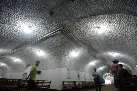 Local citizens enjoy the coolness inside the aid-raid shelter, as local administration opens the city's 9 funk holes gratis for people to dodge away from the sweltering weather and prevent sunstroke in Hangzhou City, east China's Zhejiang Province, July 1, 2009. [Zhu Yinwei/Xinhua]