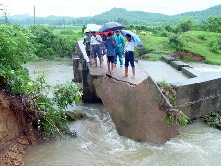 Villagers check the bridge damaged by the flood in Le'an County of east China's Jiangxi Province, July 2, 2009. A storm hit Le'an County from Wednesday to Thursday. [Xinhua]