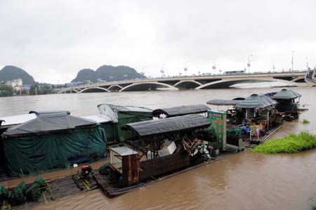 Halted bamboo rafts are seen on the Lijiang River in Guilin, a city of southwest China's Guangxi Zhuang Autonomous Region, July 3, 2009. Due to heavy rainfall, the water level of Lijiang River reached 147.5 meters at 17:00 pm on Friday, 1.8 meters over the alert level. Some scenic spots in Guilin City has been closed. (Xinhua/Chen Ruihua) 
