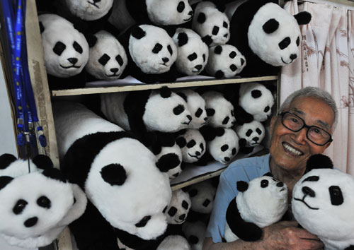 A 91-year-old citizen takes the plush panda dolls he made himself in his arms, in a photo published on Thursday, July 2, 2009. Liang Guanjun, the old man from Wuhan, central Hubei Province, became obsessed with handicraft panda toys in 2008. He and his student have manufactured over 1,000 such panda items since then, including panda dolls, panda block prints, panda masks, panda badges, panda robes and other panda adornment accessories. [Photo: CFP/Zhou Chao]