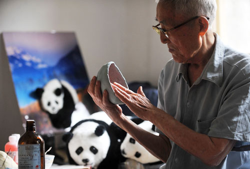 Making the panda dolls more vivid, 91-year old citizen Liang Guanjun moulds the dolls with silica gel in a photo published on Thursday, July 2, 2009. The handicraft panda toy products made by him and his student include panda dolls, panda block prints, panda masks, panda badges, panda robes, panda adornments, and are well received in market. [Photo: CFP/Zhou Chao]