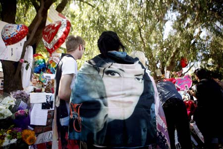 Fans pay tribute by a memorial for deceased pop star Michael Jackson outside the Jackson family home in Encino, California July 3, 2009.