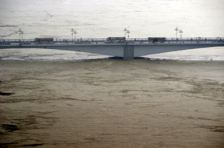 The Liujiang Bridge is seen in the flood in Liuzhou, southwest China's Guangxi Zhuang Autonomous Region, July 4, 2009. Guilin, Hechi, Liuzhou, Laibin and Baise, cities in Guangxi Zhuang Autonomous Region, suffered the disaster of floods as torrential rains hit northwest and central Guangxi since June 30. The floods afflicted 914,500 people in Guangxi, according to the figures released on Saturday. (Xinhua/Huang Xiaobang)